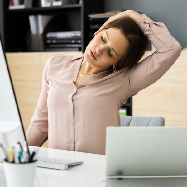 Woman stretching her neck to the side at work
