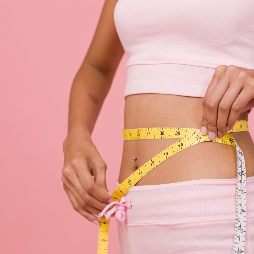 woman holding a tape measure around her waist